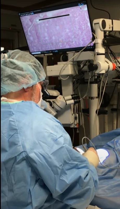 A surgeon performing eyelid surgery with imaging guidance